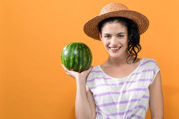 Fototapeta premium Young woman holding watermelon on a solid background