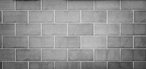 High resolution full frame background of a new, modern and clean wall or building exterior made of stone slabs in black and white. Vignetting and copy space.