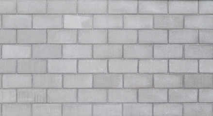 High resolution full frame background of a wall or building exterior made of light gray concrete blocks. Copy space.