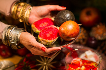 Cropped Hand with Winter Fruits on decorated Table