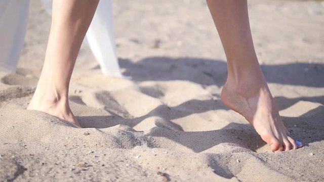 Carefree girl runs along the sand in a beautiful dress. Summer, sand, beautiful legs