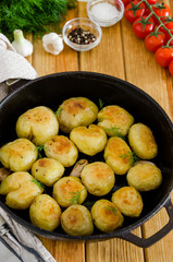 Fried Young Potatoes in a cast iron pan with garlic and dill. Rustic style.