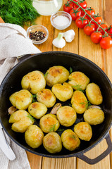 Fried Young Potatoes in a cast iron pan with garlic and dill. Rustic style.
