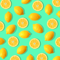 Summer fruit pattern of lemons and lemon slices on a teal green background