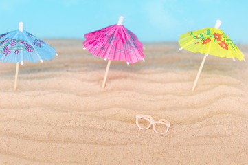 Umbrellas on the sandy beach. Tropical vacation background. Copy space, top view.