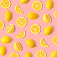 Fototapeta premium Summer fruit pattern of lemons and lemon slices on a soft pink background