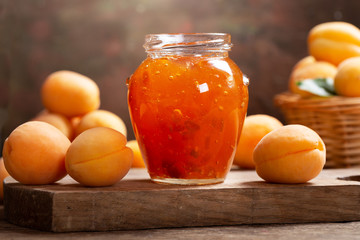 Fototapeta na wymiar glass jar of apricot jam with fresh fruits