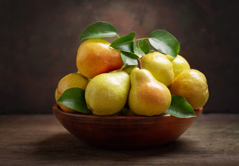 fresh ripe pears with leaves in a bowl