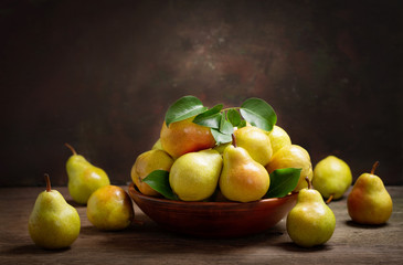 fresh ripe pears with leaves in a bowl