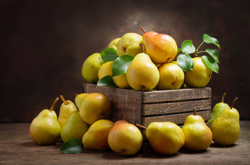 fresh pears with leaves in a wooden box