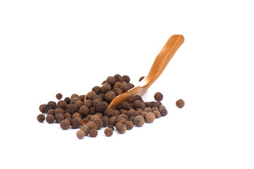 Pepper allspice on culinary wooden scoop isolated on white background. Jamaican bell pepper.