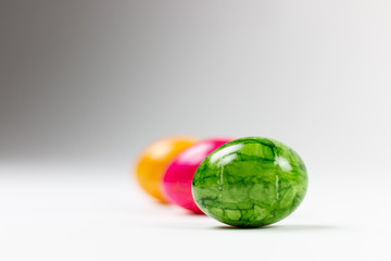 Fototapeta premium bunte kitschige Ostereier in Reihe grün rosa gelb