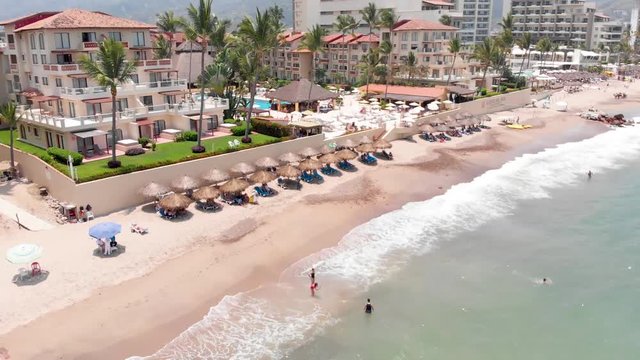 Aerial footage of the beautiful beach and hotels of Puerto Vallarta in Mexico, the town is on the Pacific coast in the state known as Jalisco showing the mountains in the background