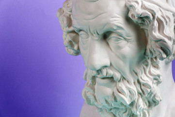 Gypsum copy of ancient statue Homer head on a blue background. Plaster sculpture man face.