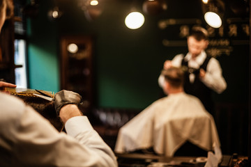 Working in barbershop. Make hair and hair styling. Working space in barbershop. Barber in work. Haircut in barbershop.