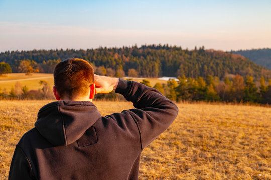 junger Mann schaut zuversichtlich in die Ferne Landschaft