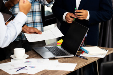 Young businessmen are meeting about stocks and earnings and their income is in the office. They are analyzing and determining the market direction in the next quarter of the year. Business concept