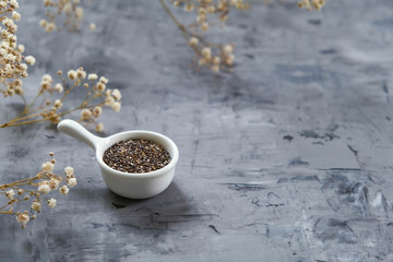 Chia seeds on a gray concrete background. Healthy food, vegetarian. Diet