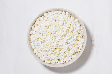 bowl of fresh farm cottage cheese on a white background, top view