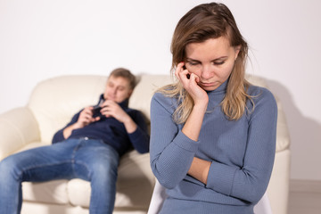 domestic violence, abuse and family concept - crying woman and her husband on the background