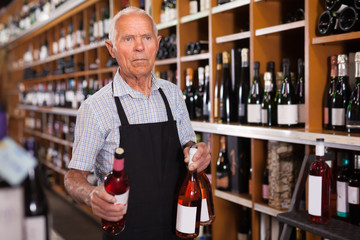 Fine male vintner working in modern wine shop