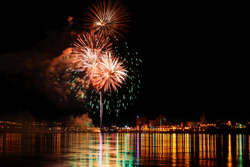 Long Exposure of Fireworks Reflecting on Calm Rippling Water