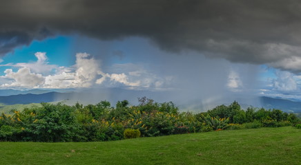 view panorama of heavy raining on top hill with dark cloudys background at Phu Chu Camp Ground, Sri Nan National Park, Nan, Thailand.
