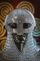 Weapons Viking helmet with chain mail of iron on red shield of wood and golden triskel