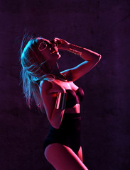 Beautiful fashion sexy blonde woman posing in blue and pink neon light in fashion in sunglasses and underwear