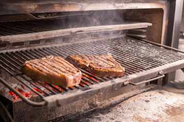 food, craft and delicious concept - cooking steak on a grill