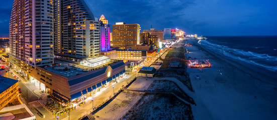 Aerial panorama of Atlantic city along the boardwalk at dusk. In the 1980s, Atlantic City achieved nationwide attention as a gambling resort and currently has nine large casinos.