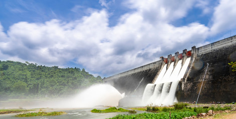 Long exposure photo of water release at spillway or overflows at big dam with blue sky and clouds (Khun Dan Prakan Chon dam in Nakhon Nayok province Thailand)
