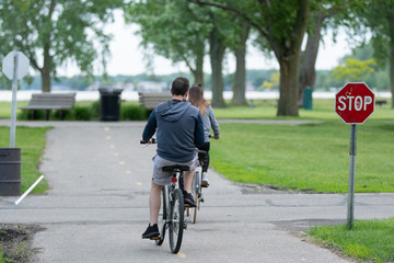 unknown couple take a bike ride in the park to stay fit after work
