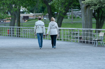 unknown senior couple take a walk in the park to stay fit on a chilly day