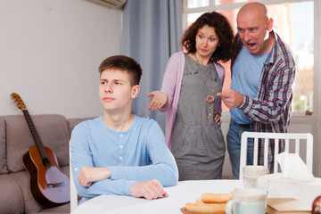 Teenager listening to reprimanding parents