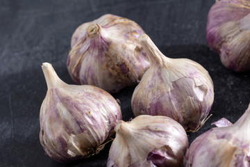 few garlic heads on dark background