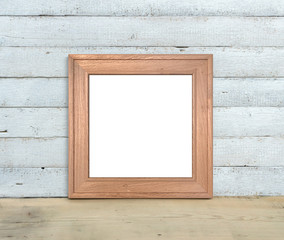 Square Old Wooden Frame mockup stands on a wooden table on a painted white wooden background. Rustic style, simple beauty. 3d render.