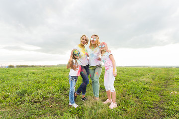 Family, festival of holi and holidays concept - portrait of happy family covered in paint