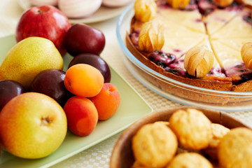 Close-up of holiday table with sweet food and desserts for tea party at home, fresh fruits and delicious cake