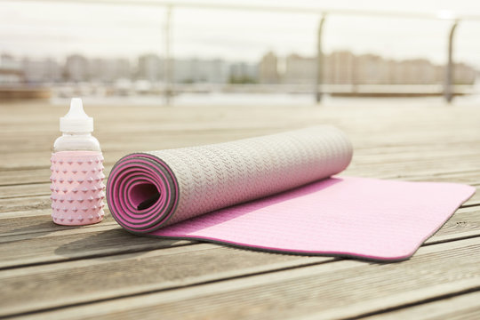 Background Image Of Pink Yoga Mat Set For Workout On Wooden Pier Outdoors, Copy Space