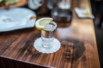Obraz na płótnie Canvas shot glass filled with tequila service with lemon and salt