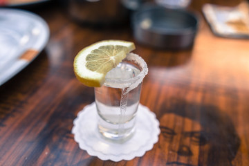 shot glass filled with tequila service with lemon and salt