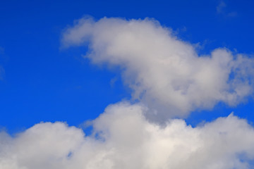 Fluffy white clouds in a deep blue sky