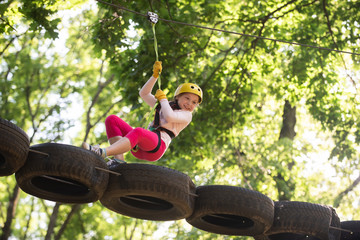 Eco Resort Activities. Climber little girl on training. Children fun. Rope park. Active children. Playground. Climber child. Teenager girl adventure and travel. Adventure climbing high wire park.
