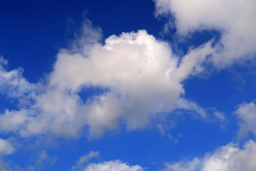 hisps of white clouds in a deep blue sky