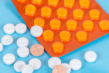 Close up of pills and a blister pack on a blue table