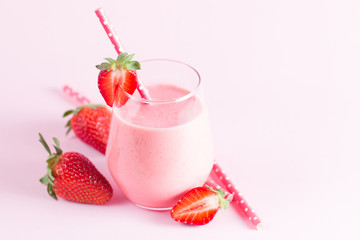 A glass of fresh strawberry smoothie on a wooden background. Summer drink shake, milkshake, juice and refreshment organic concept.