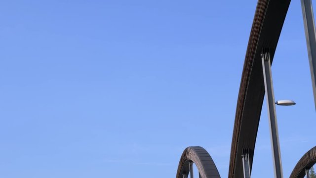 Tilt down shot of the trysil river flowing slowly under a tied arch bridge in Norway.