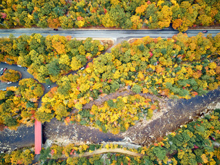 Scenic highway with covered Albany Bridge at autumn in New Hampshire, USA. Fall in New England....