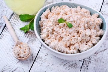 Cottage cheese of baked milk against the white wooden background
